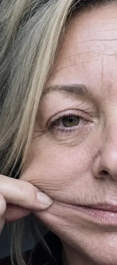 Close-up of a woman examining the skin near her mouth